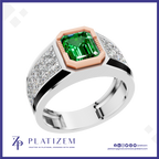 A platinum ring featuring a large emerald-cut green gemstone in a rose gold bezel, with diamond-set shoulders on a white background with the Platinzem brand logo.
