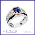 A men's statement ring by Platinzem, featuring a large emerald-cut blue sapphire center stone, a rose gold octagonal crown, and a silver-toned band paved with small clear stones.
