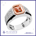 A platinum ring featuring a large emerald-cut orange gemstone in a rose gold bezel, with a silver-colored band accented by pavé-set clear crystals. The brand logo 'Platizem' is visible at the bottom of the image.