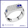 A platinum men's ring by Platinzem, featuring a rectangular top set with clear pavé stones, a blue hexagonal sapphire on the left, and a blue enamel geometric accent on the right, shown on a white background with a blue border.
