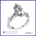 A platinum engagement ring featuring a large marquise-cut clear gemstone in a prong setting, with a detailed filigree band. The brand logo 'PLATIZEM' is visible at the bottom of the image.