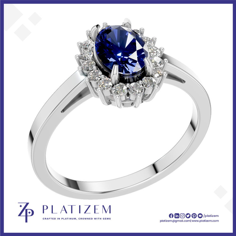 A silver-plated halo ring featuring a round deep blue sapphire center stone and surrounded by small clear accent stones, shown on a white background with the Platisem brand logo at the bottom.