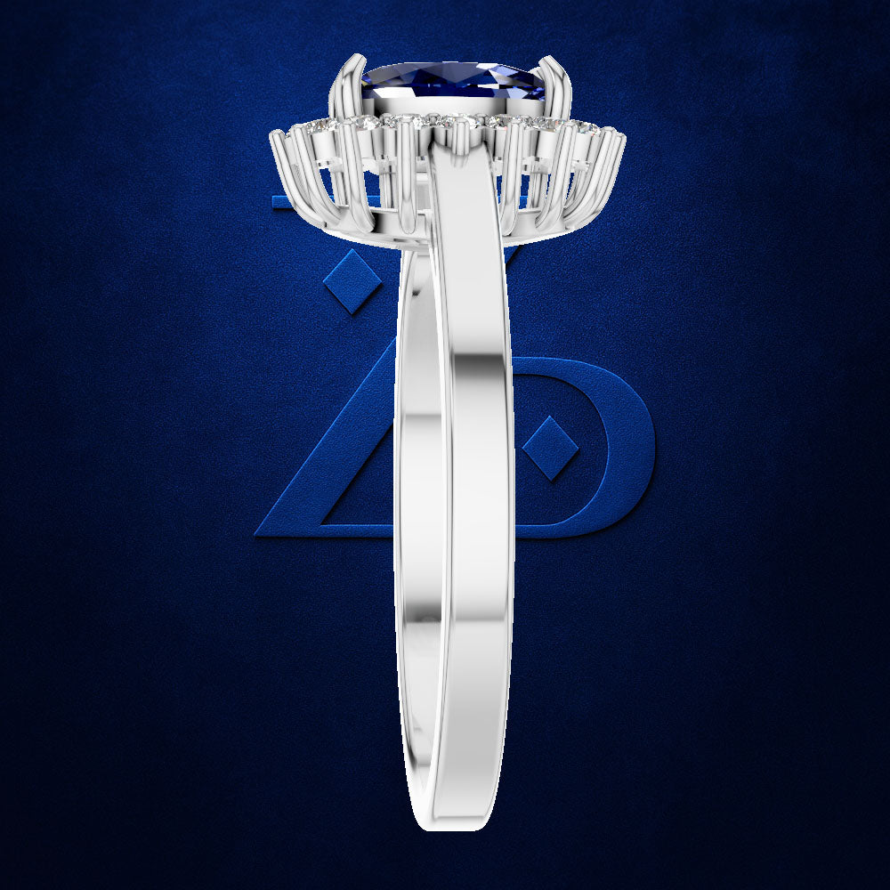A silver-toned halo ring featuring a round deep blue gemstone and baguette side stones, shown from the top-down view against a textured dark blue background.