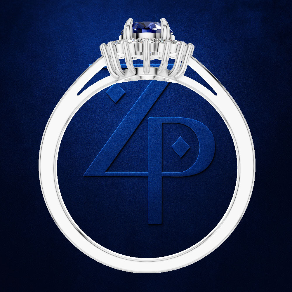 A silver-toned ring with a round blue gemstone and a large embossed blue monogram on the band, shown against a dark blue textured background.