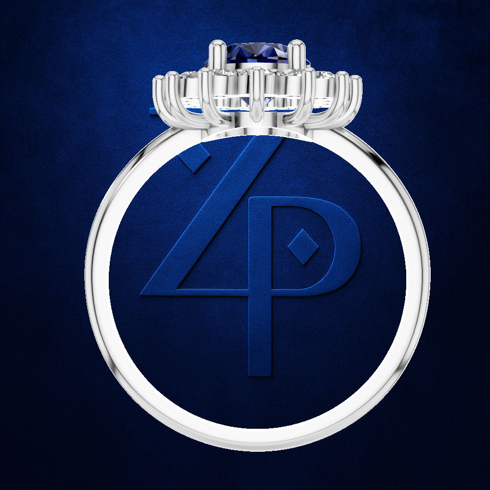 A silver-toned ring with a large circular face, a deep blue inlay, and a stylized interlocking 'Z' and 'P' monogram, topped with a small blue gemstone, set against a textured dark blue background.
