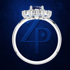 A silver-toned ring with a large circular face, a deep blue inlay, and a stylized interlocking 'Z' and 'P' monogram, topped with a small blue gemstone, set against a textured dark blue background.