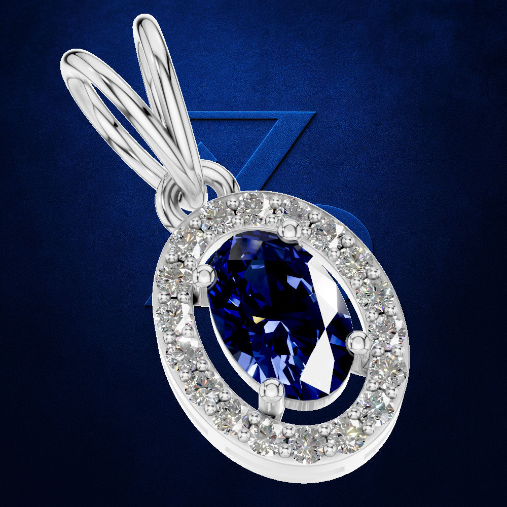 A silver-toned oval pendant featuring a large deep blue marquise-cut center stone surrounded by a halo of small clear stones, shown on a dark blue textured background.