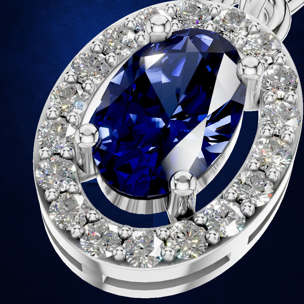A close-up of a silver-toned oval pendant featuring a large deep blue marquise-cut center stone surrounded by a halo of clear round and round-cut stones, set against a dark blue background.