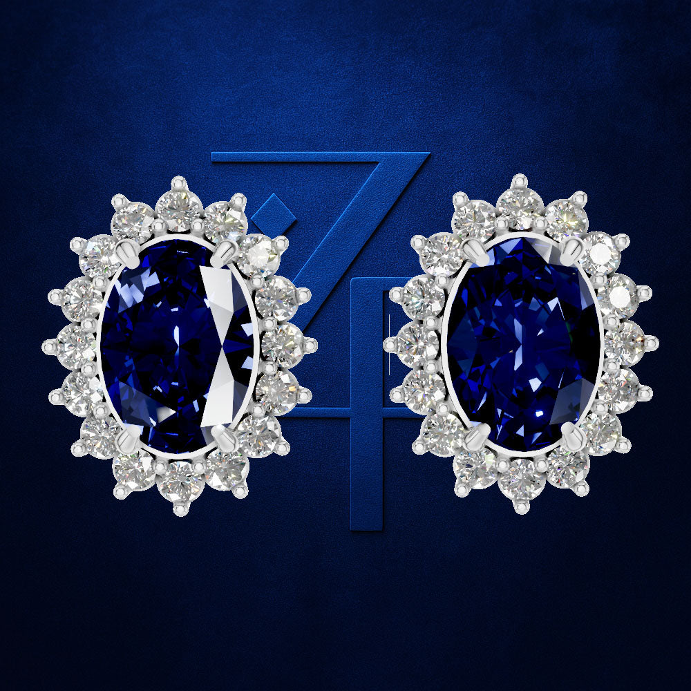 A pair of oval stud earrings featuring deep blue sapphires surrounded by clear round diamonds in a halo setting, presented on a textured dark blue background with a stylized '74' graphic.