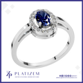 A silver-plated halo ring featuring a round-cut deep blue sapphire center stone surrounded by a halo of small clear stones, shown on a white background with the Platiszem brand logo at the bottom.