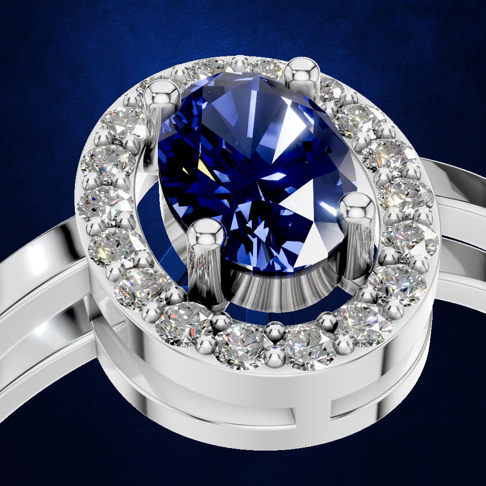 A close-up of a silver-toned ring featuring a large oval-cut deep blue gemstone in a prong setting, surrounded by a halo of small clear stones, set against a dark blue background.
