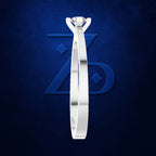 A silver-toned solitaire engagement ring with a round brilliant-cut diamond, shown vertically against a textured dark blue background with a subtle stylized 'ZD' logo.