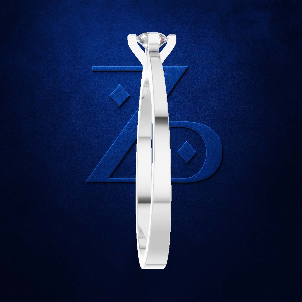A silver-toned solitaire engagement ring with a round brilliant-cut diamond, shown vertically against a textured dark blue background with a subtle stylized 'ZD' logo.