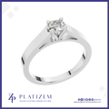 A classic solitaire engagement ring with a round brilliant-cut diamond set in a polished white gold or platinum band, presented on a white background with a blue border and the Platizem brand logo at the bottom.