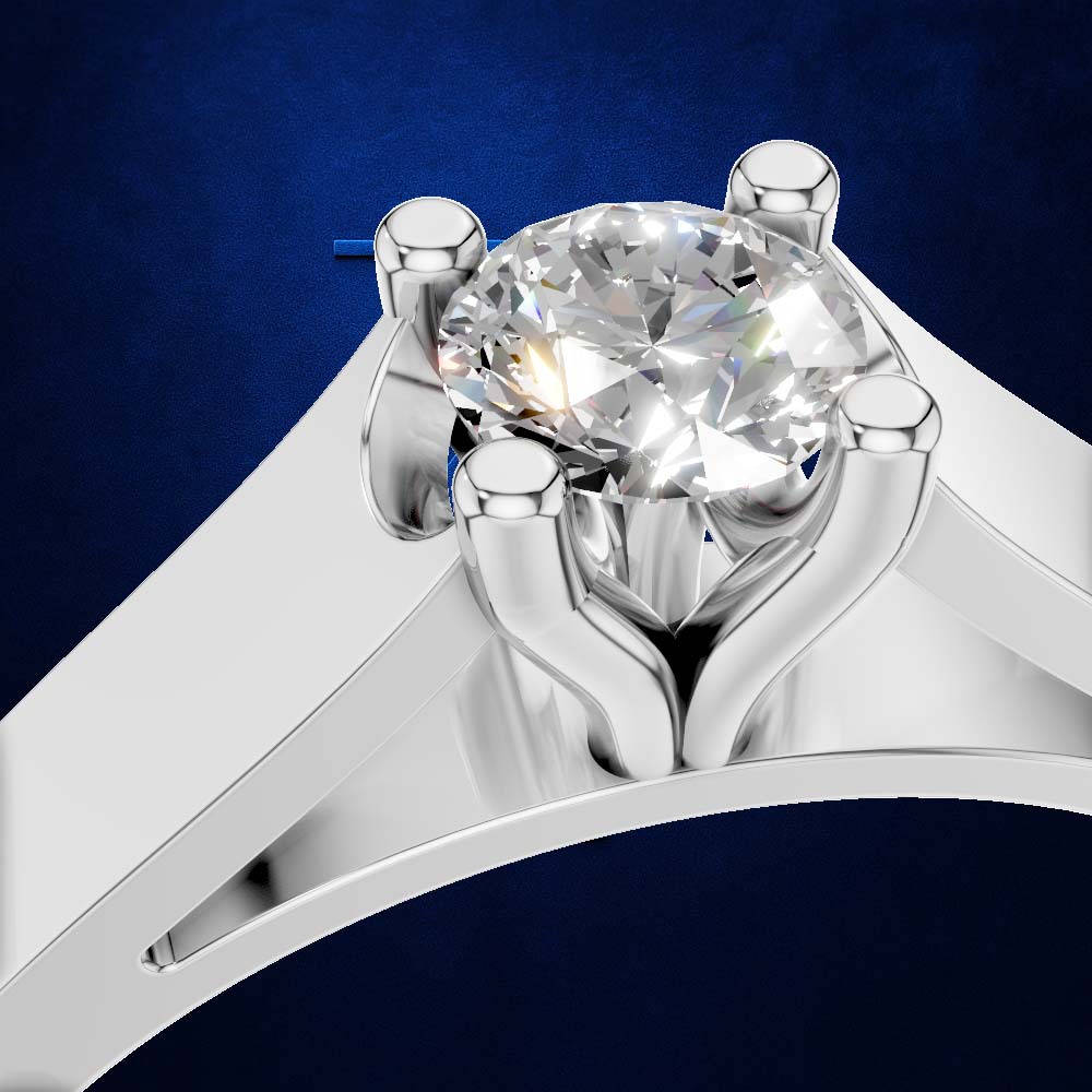 A close-up studio shot of a silver-toned solitaire ring with a large round brilliant-cut clear gemstone, set against a dark blue textured background.