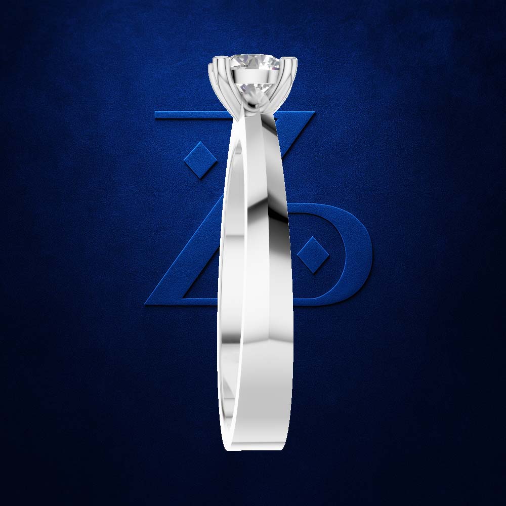 A polished silver-toned solitaire engagement ring with a round brilliant-cut diamond, shown vertically against a textured dark blue background with a subtle stylized logo.