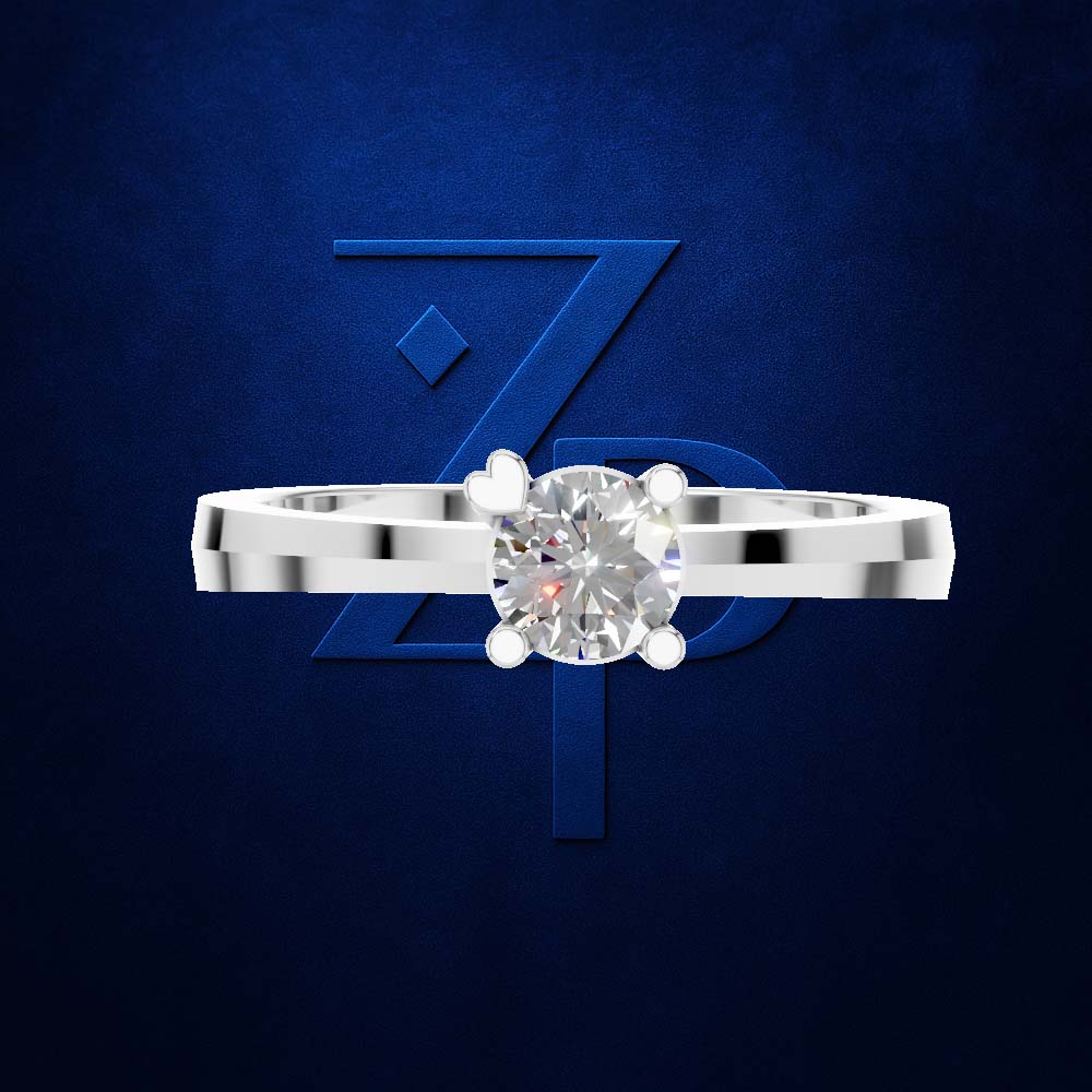 A silver solitaire engagement ring with a round brilliant-cut diamond center stone, presented against a textured dark blue background with a stylized blue 'ZP' logo.