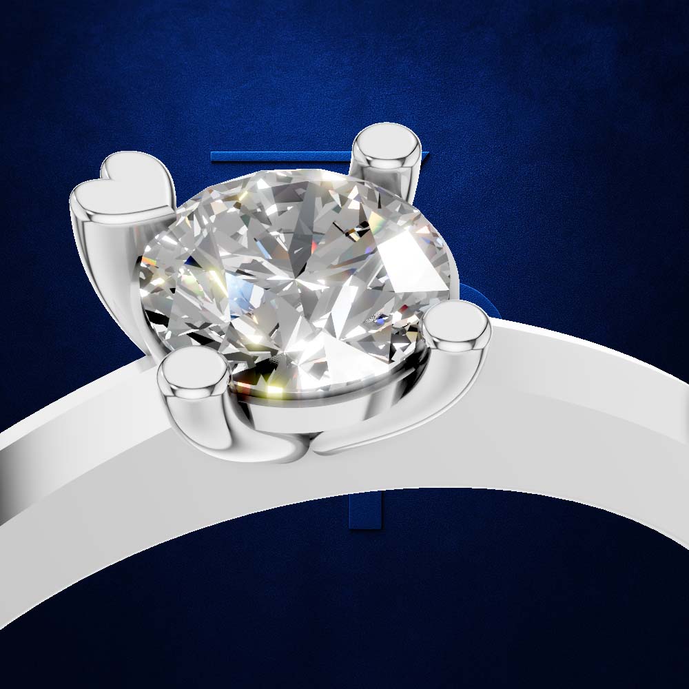 A close-up studio shot of a solitaire ring featuring a round brilliant-cut clear gemstone in a polished silver-colored setting, mounted on a curved white band against a textured dark blue background.