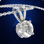 A silver-toned round-cut diamond pendant necklace with a matching chain, shown against a dark blue textured background.