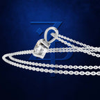 A silver-toned chain necklace with a padlock-shaped pendant featuring a clear gemstone, displayed against a dark blue textured background with a faint blue logo.