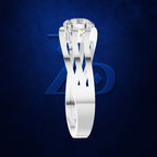 A white gold or platinum solitaire engagement ring with a round brilliant-cut diamond, shown against a dark textured blue background with a subtle logo.