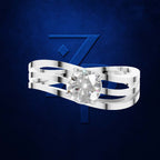 A silver-toned multi-band ring with a large round-cut clear gemstone, shown against a dark blue textured background with a stylized blue 'Z' logo.