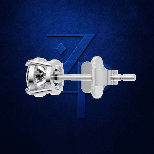 A close-up studio shot of a silver-toned stud earring with a clear faceted gemstone, shown from the back against a dark blue textured background with a subtle stylized logo.