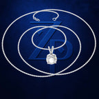 A silver-toned chain necklace with a clear round-cut gemstone pendant, arranged in concentric circles over a dark blue textured background with a large stylized ZP logo.