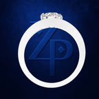 A white circular ring with a top setting holding a clear gemstone, centered over a dark blue textured background. The ring overlaps a large embossed blue monogram logo consisting of stylized 'Z' and 'P' letters.