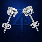 A pair of silver stud earrings with clear round-cut gemstones and decorative screw-back closures, displayed on a dark blue textured background with a large blue monogram logo behind them.