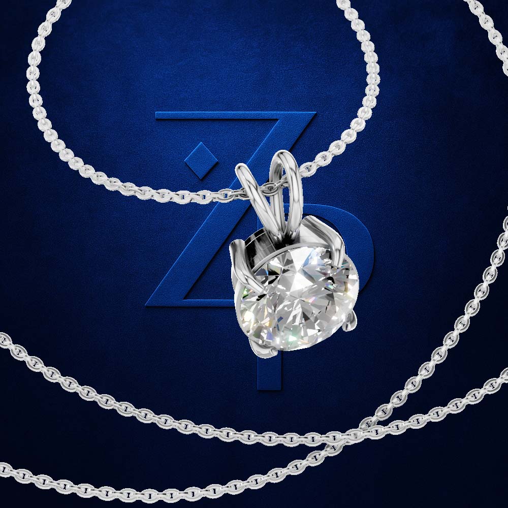 A silver-tone necklace with a round brilliant-cut clear gemstone pendant, displayed on a dark blue background with a large stylized 'Z' logo and additional chain loops.
