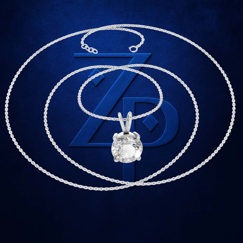 A silver-toned necklace with a clear round-cut gemstone pendant, arranged in concentric loops over a dark blue textured background with a large stylized ZP logo.