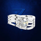 A silver-toned multi-band ring featuring a large, round brilliant-cut diamond center stone, presented against a textured dark blue background with a stylized blue 'Z' logo.