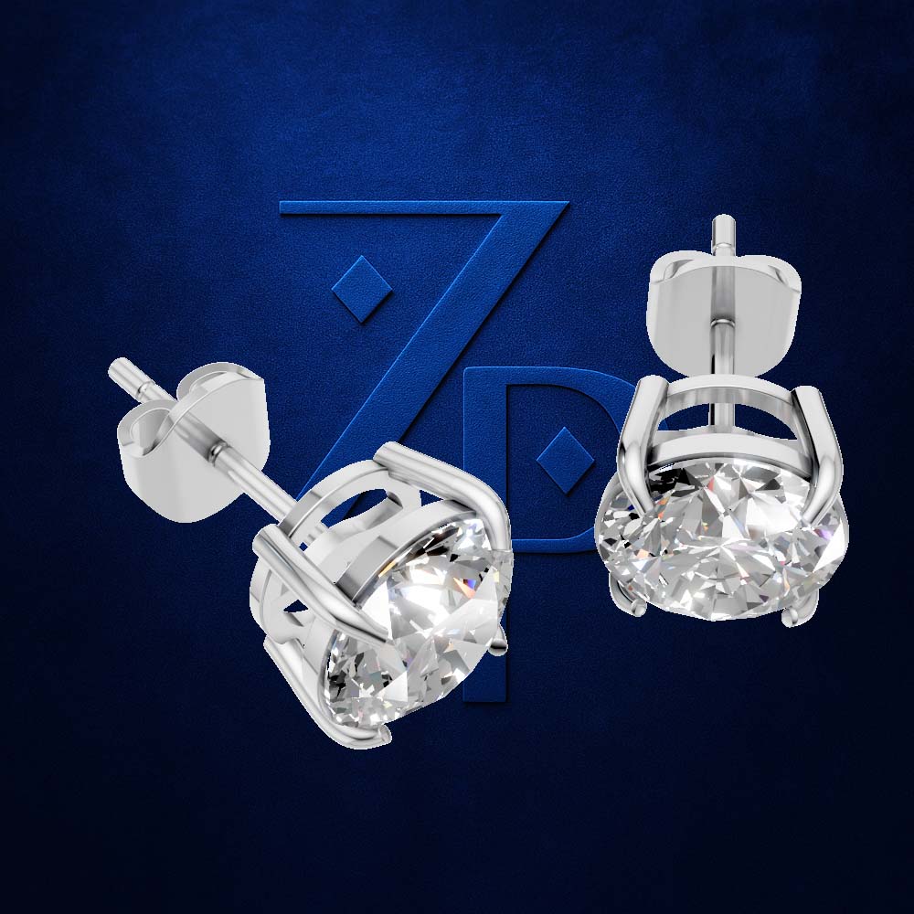 A pair of silver stud earrings with round clear gemstones in a prong setting, shown against a dark blue textured background with a large blue stylized 'ZP' logo behind them.