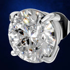 A round brilliant-cut diamond solitaire ring in a polished silver-toned four-prong setting, shown against a dark blue textured background.