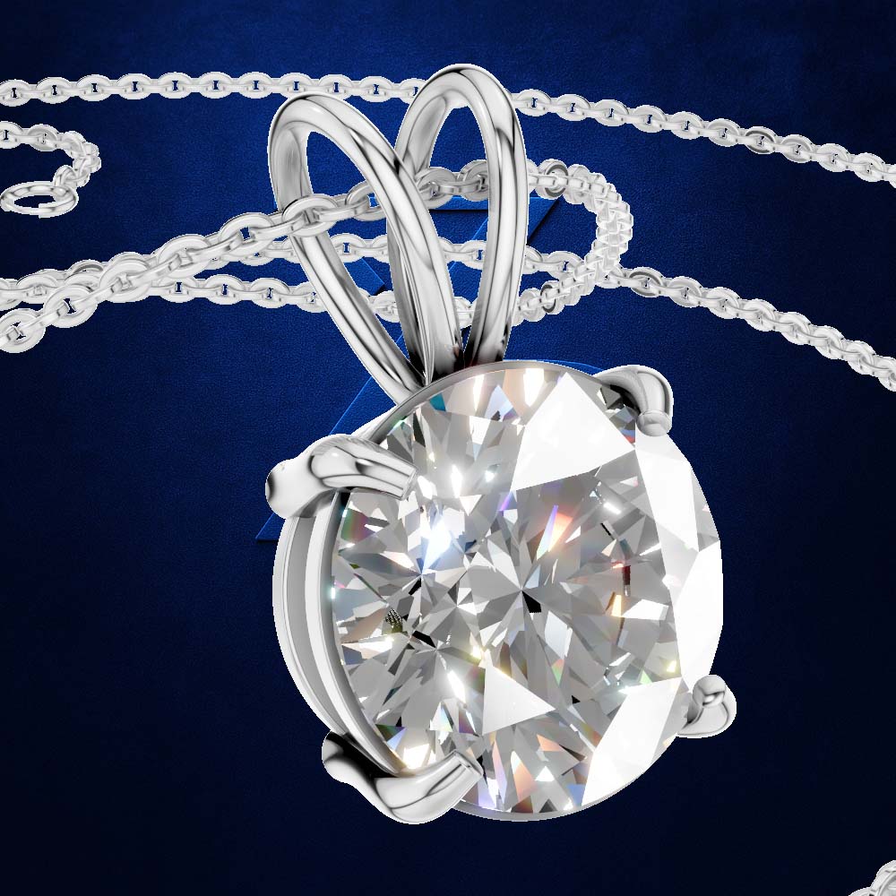 A silver-toned solitaire pendant necklace featuring a large, round brilliant-cut clear gemstone in a prong setting, suspended from a matching chain against a dark blue textured background.