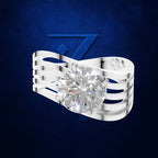 A silver-toned ring with a large round brilliant-cut clear gemstone, shown against a dark blue textured background with a subtle blue geometric logo behind it.