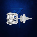 A polished silver-toned stud earring with a bezel-set clear gemstone and matching post/backings, shown against a dark blue textured background with a subtle blue geometric logo behind it.