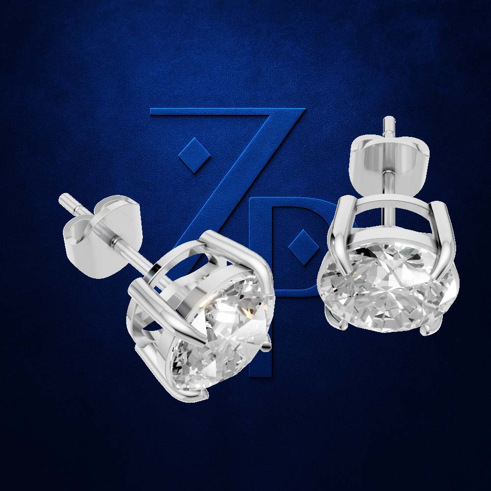 A pair of silver-toned diamond stud earrings shown on a dark blue textured background with a large blue ZP logo behind them. One earring is shown from a side angle and the other from a top-down angle.