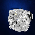 A round brilliant-cut diamond solitaire setting in a polished silver-colored metal, shown against a textured dark blue background.