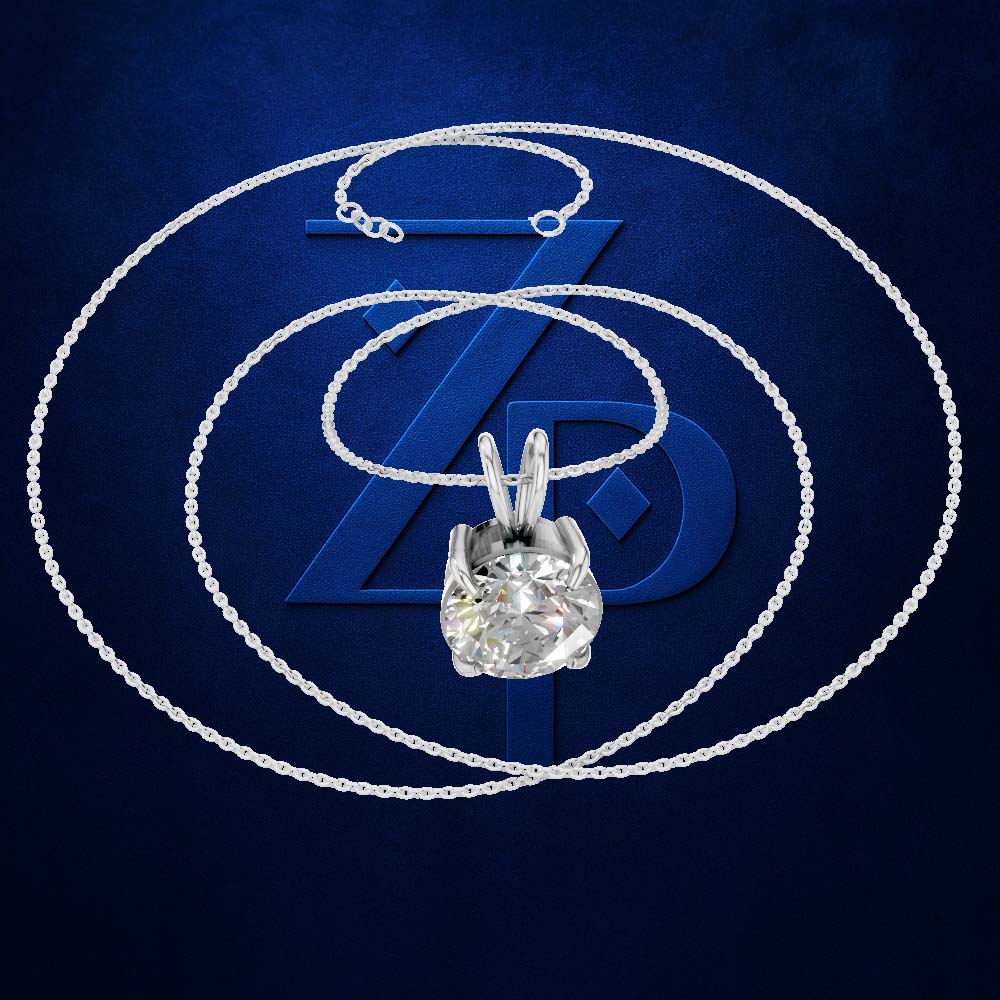 A silver-toned necklace with a clear gemstone pendant in a prong setting, displayed against a dark blue textured background with a large stylized blue Z logo behind it.