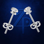 Two polished silver-toned jewelry pieces with ornate scrollwork ends and a central geometric emblem, arranged symmetrically on a dark blue textured background with a large blue monogram behind them.