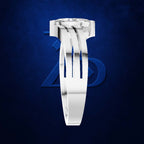 A white gold or platinum solitaire ring with a round brilliant-cut diamond, shown on a textured dark blue background with a subtle logo behind it.