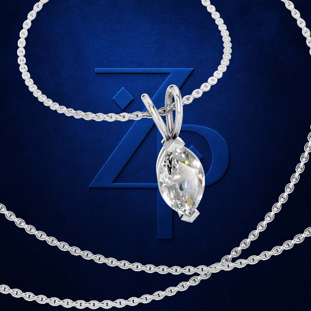 A silver-tone necklace with a marquise-cut clear gemstone pendant, arranged on a dark blue textured background with a large blue monogram behind it.
