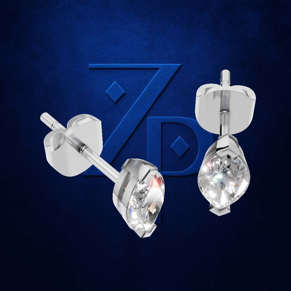 A pair of silver stud earrings with teardrop-shaped clear gemstones, shown from multiple angles against a textured dark blue background with a stylized 'ZD' logo.