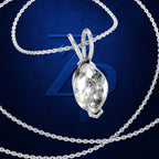 A silver-toned teardrop-shaped crystal pendant necklace with a matching chain, displayed against a dark blue textured background with a large stylized '7' behind it.