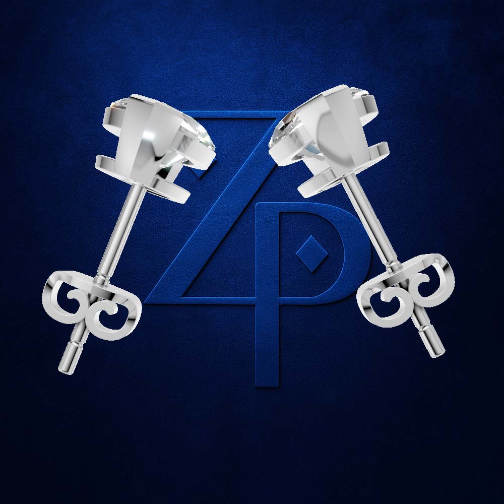 A pair of polished silver stud earrings with round faceted clear gemstones and butterfly backings, displayed against a dark blue textured background with a large blue monogram logo.