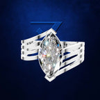 A silver-toned ring featuring a large marquise-cut clear gemstone in a prong setting, mounted on a wide, multi-strand polished band. The ring is centered against a textured dark blue background with a subtle blue geometric logo behind it.