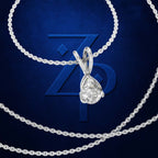 A silver-toned necklace with a teardrop-shaped clear gemstone pendant, arranged on a dark blue textured background with a large embossed ZP logo behind it.