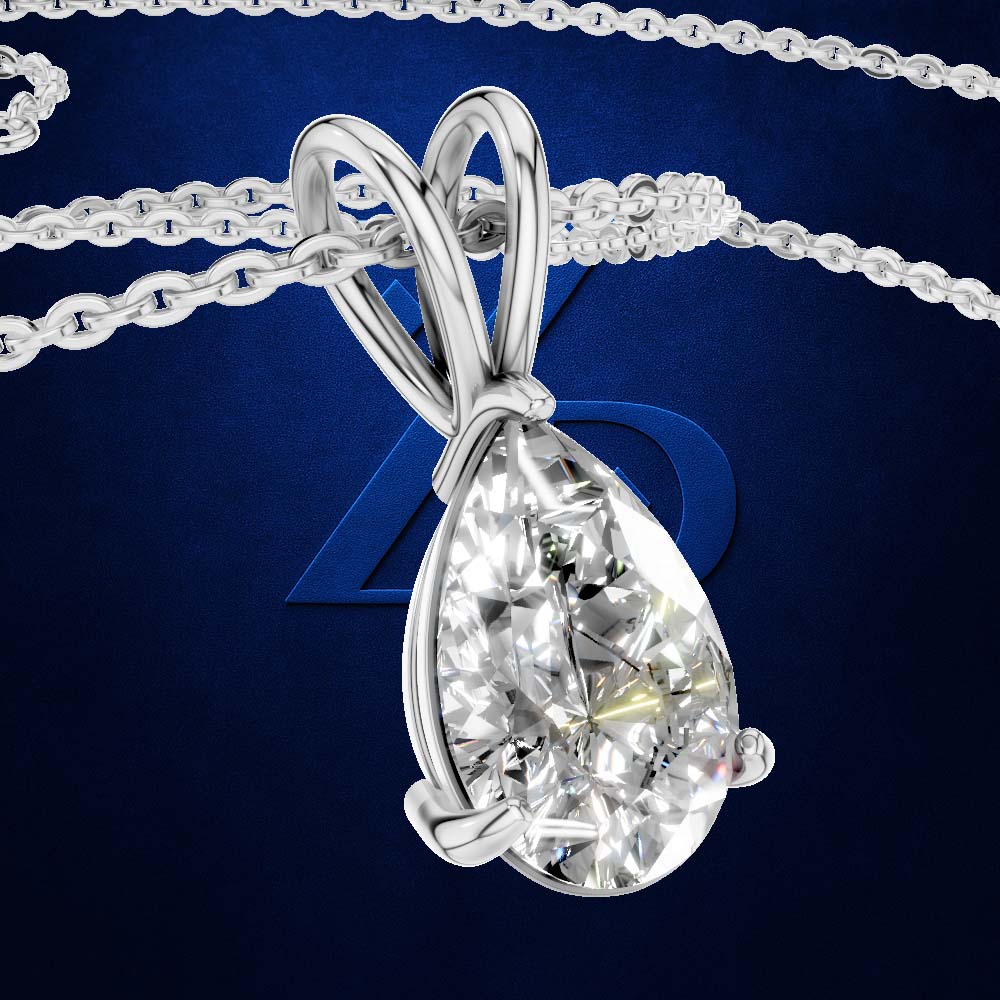 A teardrop-shaped diamond pendant in a silver-colored setting on a matching chain, set against a dark blue textured background with a subtle logo.